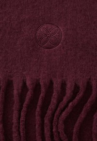 Burgundia kangas pehmea tekstuuriga; omab ümmargust logo ja pitsilise äärega. Elegantne ja mugav, sobib talviseks kandmiseks.