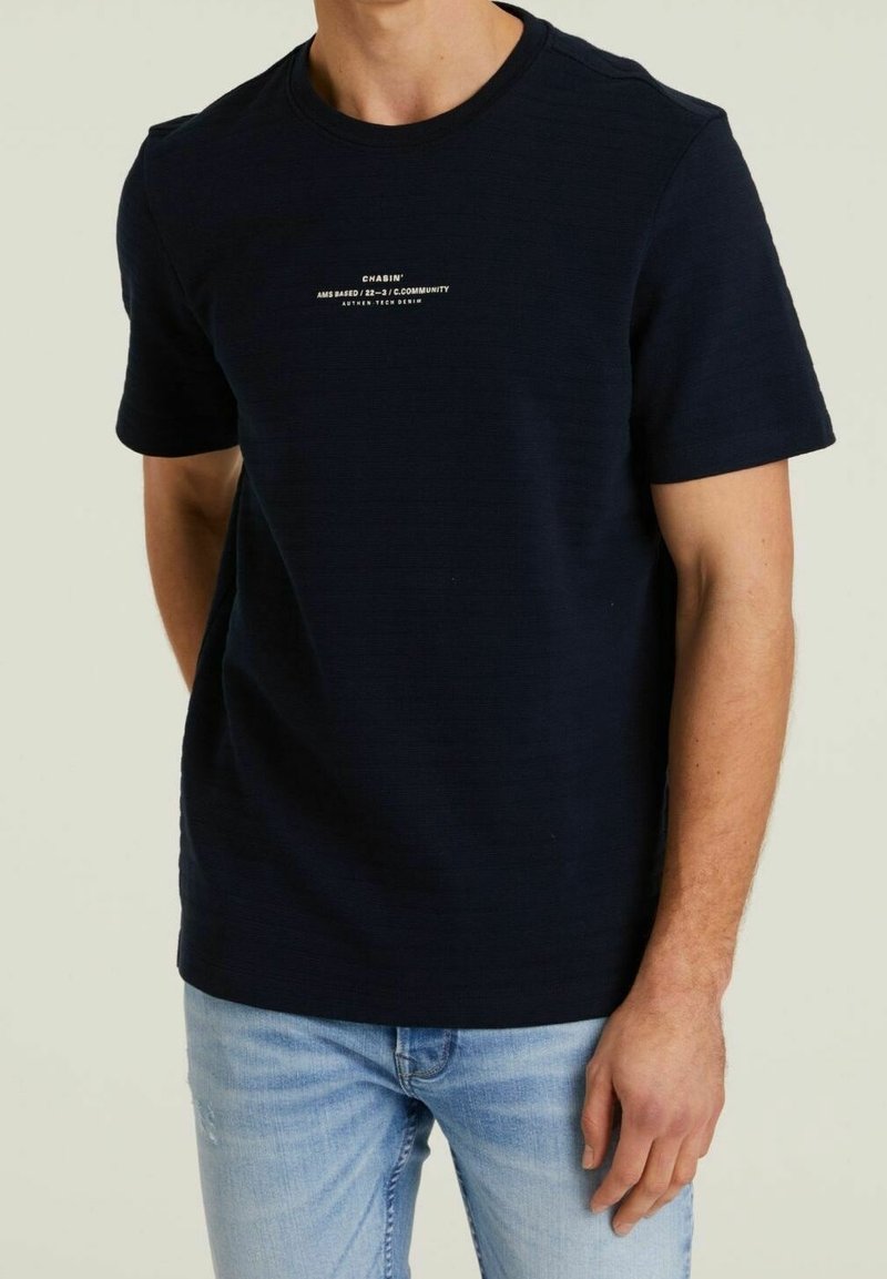 Himmelblaues T-Shirt mit kurzen Ärmeln aus strukturiertem Stoff. Mit weißem Markenlogo auf der Vorderseite. Klassischer Rundhalsausschnitt.