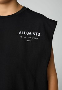 Must lähedalt must kerevaba särk, millel on valge kiri "ALLSAINTS", jaapani tähemärgid ning "LONDON" rinnal.