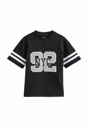 Schwarzes Baumwoll-T-Shirt mit perforiertem Design, das die Nummer "92" und "NYC" in Weiß zeigt, akzentuiert durch weiße Streifen an den Ärmeln.