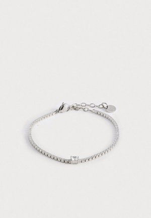 Hõbedane käevõru, millel on paindlik disain läbipaistevate ümmarguste kristallide ja ruudukujulise aktsendiga. Reguleeritav lukustus ja ketta pikendus.