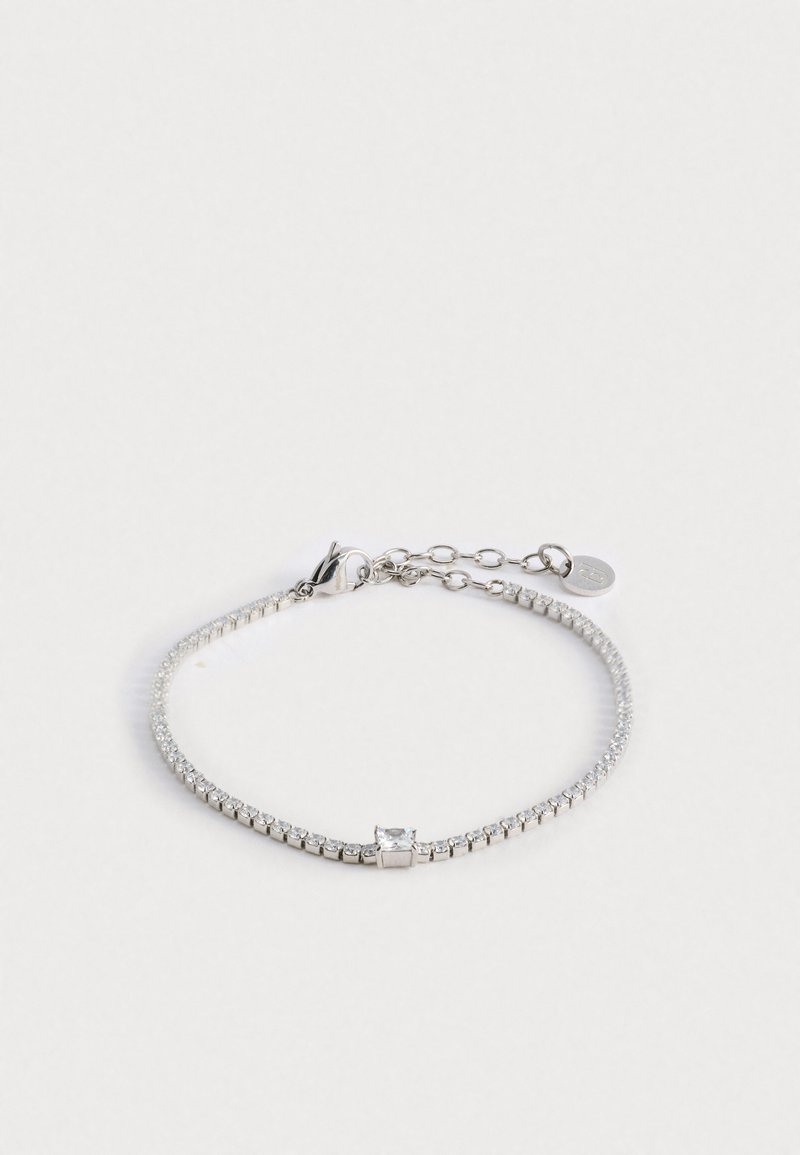 Hõbedane käevõru, millel on paindlik disain läbipaistevate ümmarguste kristallide ja ruudukujulise aktsendiga. Reguleeritav lukustus ja ketta pikendus.