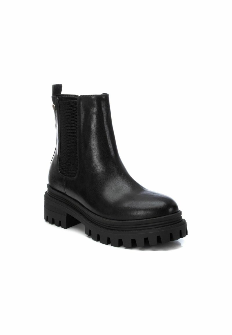 Botte en cuir noir à la cheville avec panneaux latéraux élastiques, bout rond et semelle en caoutchouc épaisse avec des rainures profondes pour l'adhérence.