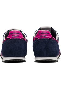 Navy suede sneakers with pink accents and a textured finish. Features "Onitsuka Tiger" branding on the heel and a rubber outsole.