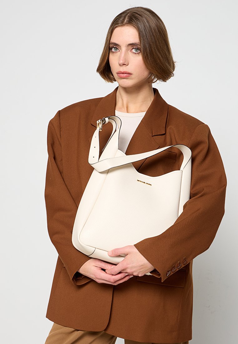 Borsa a spalla in pelle bianca con forma curva e ampia apertura, dotata di tracolla removibile e branding goffrato discreto.