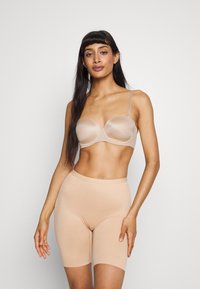 Beige undertøy med en formet bh med justerbare stropper og høyt midjestrammende shorts, begge i et glatt, elastisk stoff.