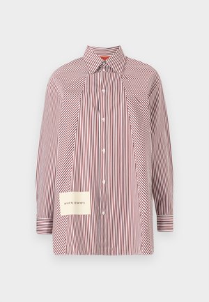 Chemise à rayures rouge et blanche avec manches longues, un col et une patch présentant des coordonnées sur le côté inférieur gauche.
