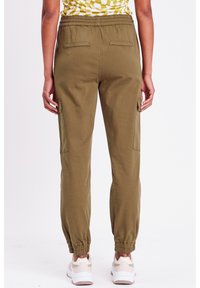 Pantaloni cargo verde oliva con cintura elastica, tasche laterali e polsini elastici. Il materiale sembra leggero con una texture liscia.