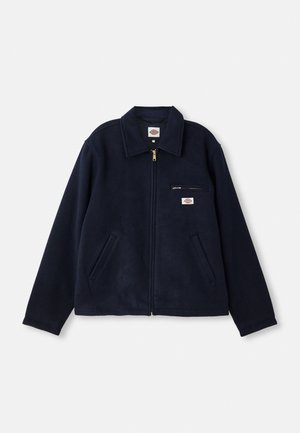 Casaco de fleece azul marinho com fecho total, gola plana, dois bolsos laterais e um bolso no peito com fecho, apresentando um logotipo da marca.