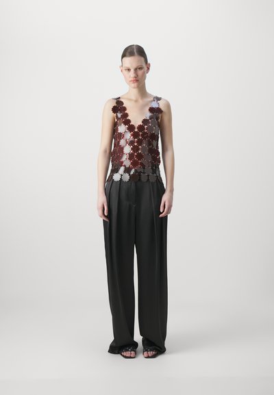 Layered floral-pattern top in burgundy and silver with deep V-neck, paired with black wide-leg trousers. Flowing fabric and relaxed fit.