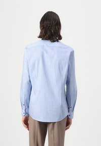 Plava i bijela prugasta košulja dugih rukava s okovratnikom na dugme i manžetama, krojena u slim fit, od glatkog pamuka.