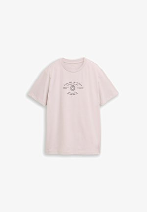 Tricou roz pal cu mâneci scurte, guler rotund și text și grafică centrate care spun „Cel mai bun loc este plaja, vibrații relaxante non-stop.”