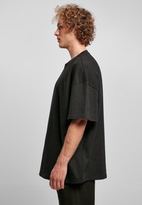 Zwarte oversized t-shirt gemaakt van katoen, met een ronde halslijn, korte mouwen en een losse pasvorm. Gestructureerde stof zonder patronen.