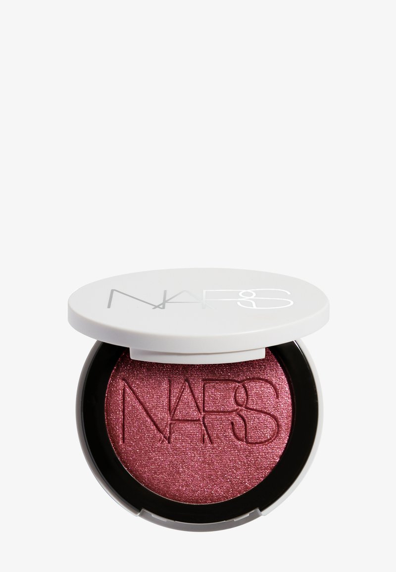 Boîtier rond de blush NARS avec couvercle blanc partiellement ouvert, montrant un blush rose profond scintillant embossé du logo NARS.
