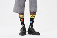 Chaussettes noires avec des motifs colorés de personnages de Star Wars, avec un bandeau jaune portant le texte "Star Wars". Portées avec des shorts en denim et des chaussures noires.