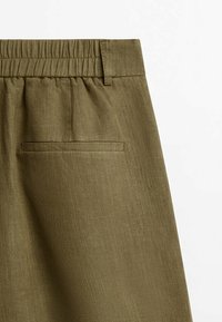 Pantalon en lin vert olive avec taille élastique, une poche arrière et une finition en tissu lisse et texturé.