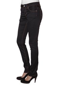 Czarne dżinsy z denimu o dopasowanym kroju, z pomarańczowymi szwami, pięcioma kieszeniami i zapięciem na guzik. Połączone z czarnymi wysokimi obcasami.