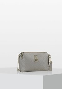 Vaaleanharmaa suorakulmainen olkalaukku, jossa on kohotettu logo-kuviointi, kultaketjuolkahda ja metalliset Guess-brändikoristeet roikkumassa sivulla.