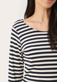 Dlouhý rukáv pruhovaný top v námořnické modré a off-white, s lodičkovým výstřihem a měkkou, elastickou tkaninou, s rovnoměrnými horizontálními pruhy po celé délce.
