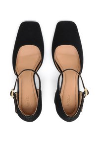 Black suede square-toed shoes with ankle straps and gold hardware accents. Light tan insoles visible, featuring subtle branding.