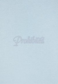 Himmelblaues Gewebe mit glatter Textur, das das Wort "Verboten" in dezent gestickter Schrift zeigt.