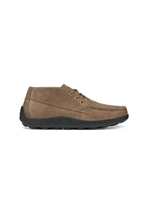 Scarpa casual alla caviglia in camoscio marrone con lacci e suola spessa in gomma nera, mostrata di lato su sfondo bianco.