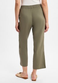 Olivenfarbene, leichte, cropped Hosen aus Stoff mit einem elastischen Bund, entspanntem Schnitt und knie-langer Saum.