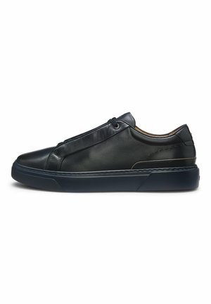 Schwarzer Leder-Sneaker mit niedrigem Schaft, dicker dunkler Sohle, Schnürverschluss und dezenten Nahtdetails, Seitenansicht.