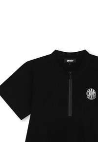 T-shirt noir DKNY à manches courtes avec un zip sur le devant, texture côtelée et logo circulaire sur la poitrine gauche.