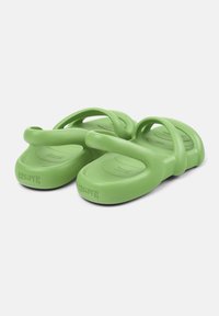 Green rubber sandals with a minimalist design, featuring two curved straps and contoured footbed. Brand name embossed on the sole.