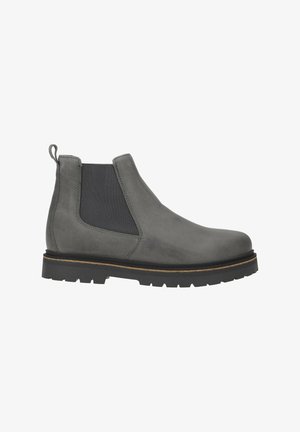 Stivali Chelsea grigi in suede con pannelli elastici neri ai lati, linguetta sul tallone e suola in gomma nera spessa a carrarmato con finiture in marrone chiaro.