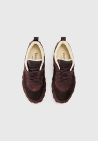 Μπορντό και σκούρα καφέ αθλητικά παπούτσια από σουέντ και δέρμα, με μαλακό εσωτερικό, δέσιμο με κορδόνια και υφή στη λαστιχένια σόλα.