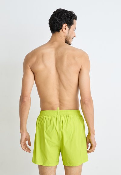 Bañador verde brillante con cintura elástica y cordón, tejido ligero, de longitud por encima de la rodilla, diseño minimalista, sin patrones.