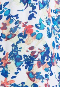 Fabric with a multicolored floral pattern in blue, turquoise, red, and light green on a white background.