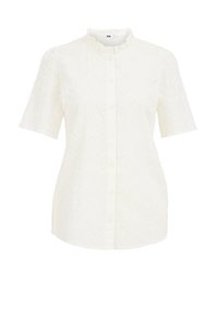 Vit kortärmad skjorta med volangkrage, med ett strukturerat zick-zack-mönster och knäppning fram.