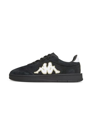 Zapatilla deportiva negra de corte bajo con cordones negros, logotipo blanco de dos figuras sentadas espalda con espalda, y acento blanco en el talón, sobre fondo blanco.