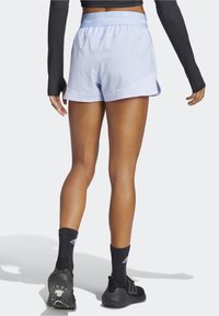 Light blue athletic shorts with a textured waistband and overlapping design, paired with black sneakers and socks featuring a logo.