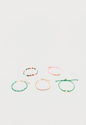Cinq bracelets sur une surface blanche : perles multicolores, cordon rose avec perles dorées, perles turquoise avec fermoir en or, chaîne en or, et cordon vert avec un charme doré.