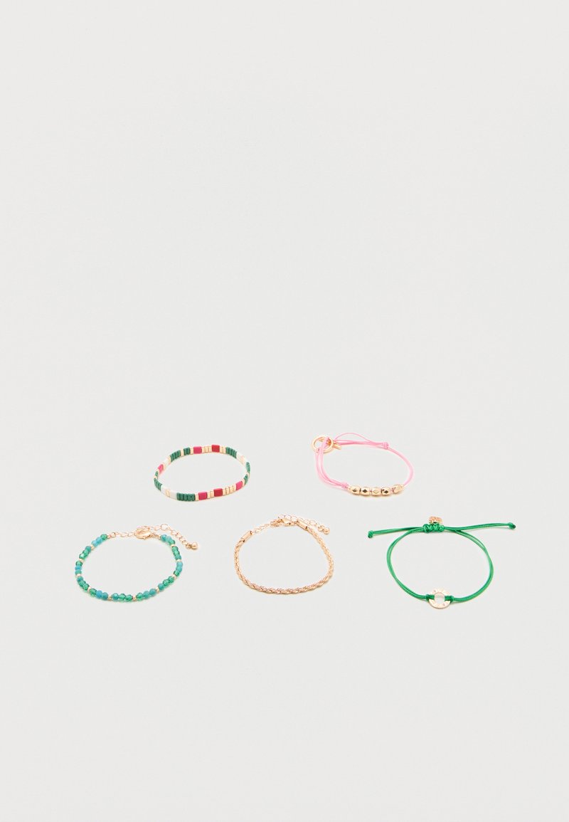 Πέντε βραχιόλια σε λευκή επιφάνεια: πολύχρωμα με χάντρες, ροζ κορδόνι με χρυσές χάντρες, τυρκουάζ χάντρες με χρυσό κούμπωμα, χρυσή αλυσίδα και πράσινο κορδόνι με χρυσό φυλαχτό.