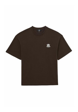Brązowa koszulka bawełniana z krótkimi rękawami i okrągłym dekoltem, z małym białym logo haftowanym po lewej stronie klatki piersiowej. Miękka faktura.