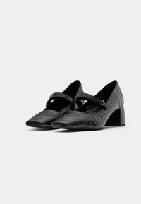 Escarpins en cuir noir gaufré crocodile avec un bout pointu, un petit talon bloc et une sangle réglable sur le cou-de-pied.
