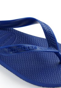 Flip-flop in gomma blu con soletta testurizzata e design a cinturino intrecciato. Presenta il logo del marchio impresso e bordi lisci.