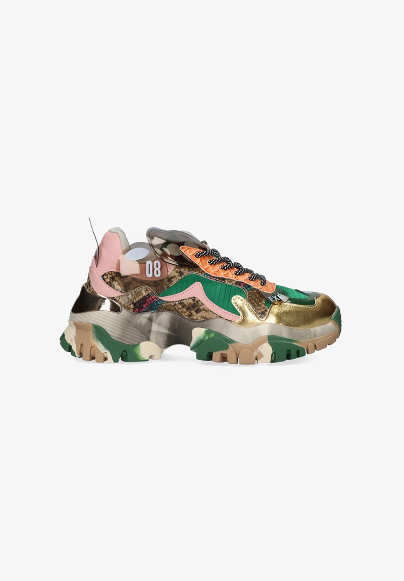 Zapatilla multicolor con un diseño metálico en dorado y verde, texturas de camuflaje y una suela gruesa; presenta cordones negros y acentos naranjas.