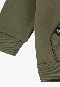 Μανίκι φούτερ σε ελιά πράσινο με ριμπ μανσέτες και ραμμένη τσέπη με μαύρο υφασμάτινο ταμπελάκι και λευκή λεπτομέρεια λογότυπου αστέρι.