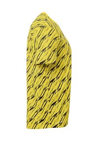 T-shirt jaune à manches courtes avec un motif noir ondulé. Fabriqué en tissu doux, avec une coupe standard et un col rond.