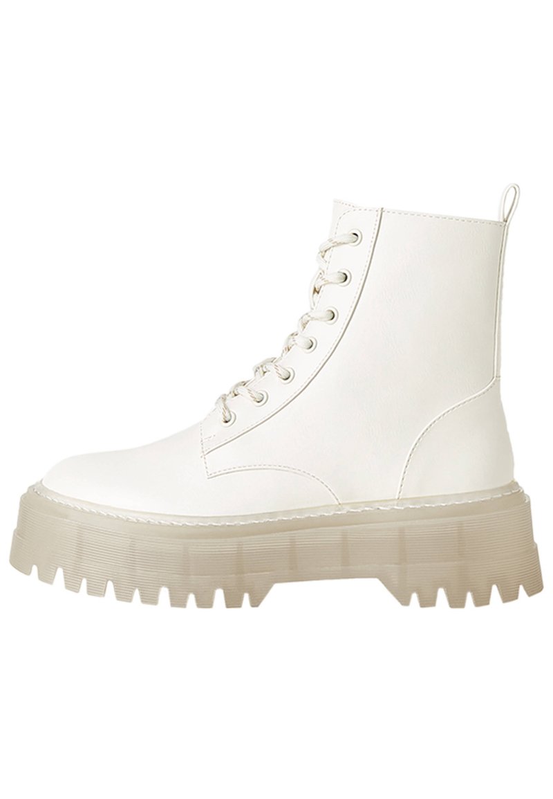 Vita snörad ankelsko i konstläder, med en robust, semi-transparent klumpig sula med ribbad textur och en dragflik.