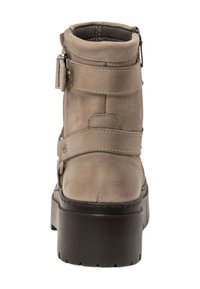 Bottine en cuir beige avec un bout arrondi, deux brides réglables, une fermeture éclair sur le côté et une semelle plateforme noire épaisse.