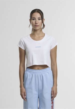 Fehér, környakú, rövidujjú póló, amelyen kék "DNGRS" logó található a mellkason, világoskék melegítőnadrággal párosítva, piros kiegészítőkkel.