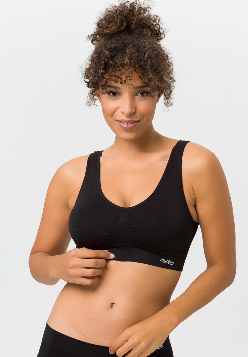 Schwarzer Sport-BH aus dehnbarem Stoff, mit breiten Trägern, einem runden Ausschnitt und einem gerafften Detail in der Mitte. Subtiles Logo am Saum.