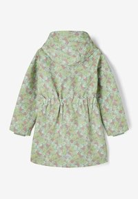 Imperméable fleuri en tissu vert doux avec motifs floraux roses et blancs, taille élastique et capuche. Présente un logo triangulaire sur l'ourlet.